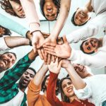Club and Groups Stock Photo with people standing in a circle with their hands in the center